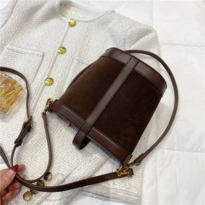 Detail view of dark brown bucket bag with smooth leather and suede stitching