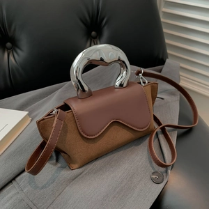 Detailed view of suede and PU leather handbag with elegant silver metal curved handle