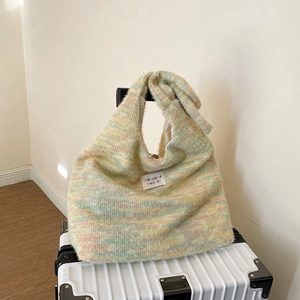 Close-up of a striped knit tote bag in pastel colors with a soft plush texture