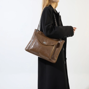 Détail d'un sac à bandoulière marron foncé en similicuir vintage avec fermoir métallique