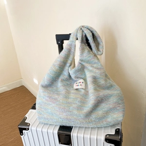 Close-up of soft chunky knit tote bag with macaron colored yarn and brand label detail