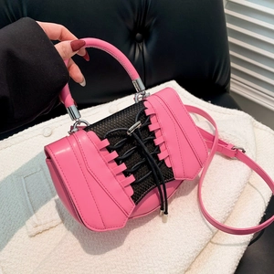 Detail of pink PU leather handbag with black mesh panels and lace-up design