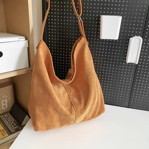 Texture dettagliata della borsa hobo in velluto a coste giallo zenzero su tavolo