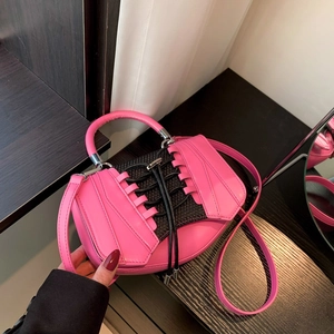 Detail of pink sneaker-style handbag with black mesh panels and lace-up design