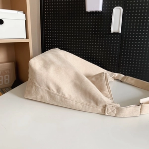 Dettaglio della borsa tote in velluto a coste crema con trama del tessuto e cuciture