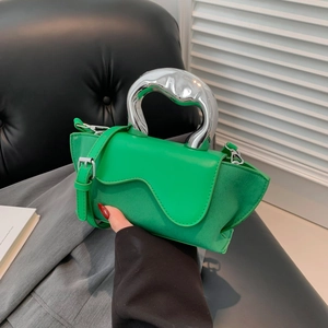 Detail of green PU suede handbag featuring a curved silver handle and wavy flap design
