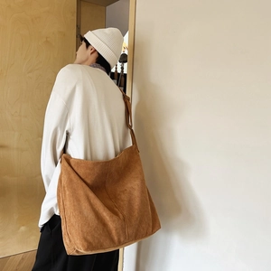 Borsa a tracolla in velluto a coste marrone indossata da modella in studio naturale