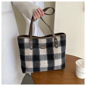 Close-up of winter buffalo check wool tote bag with premium faux leather handles and metal plate