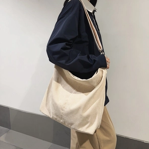 Dettaglio della borsa tote in velluto a coste bianco crema con trama a costine e tracolla