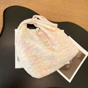 Macro shot of colorful knitted plush tote bag with rainbow texture and metal snap button