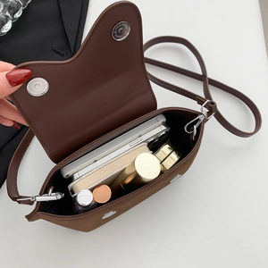 Open saddle bag showing spacious interior with phones, cosmetics and magnetic buckles
