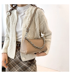 Detail of minimalist beige PU leather shoulder bag with decorative silver chain and triangle side