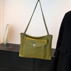 Détail du sac à bandoulière en similicuir vert avec fermoir rotatif métallique