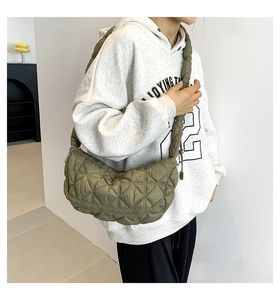 Detail of olive green quilted crescent bag featuring a unique thick braided shoulder strap