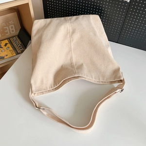 Dettaglio della borsa tote in velluto a coste crema con tracolla regolabile e fibbia in metallo