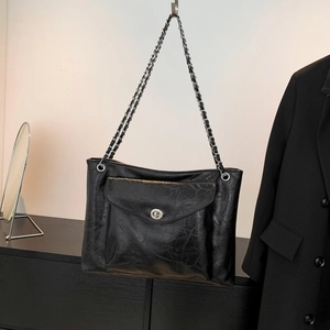 Détail du sac bandoulière en cuir PU noir avec texture froissée vintage et chaîne métal