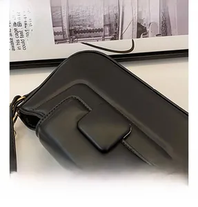 Detail view of the black PU leather handbag showing the square clasp and smooth texture