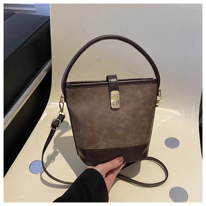Detail der zweifarbigen Bucket Bag mit Litschi-Textur und goldenem Metallverschluss