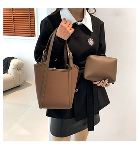 Deep brown bucket bag and matching pouch shown in a minimalist modern interior setting