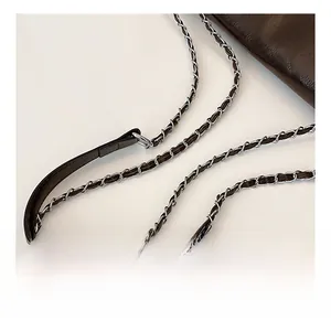 Detail of dark brown leather braided chain strap with polished metal connector rings