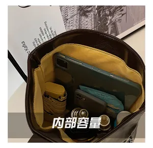 Interior detail of trendy brown PU leather handbag showing spacious storage and yellow lining