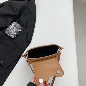 Detail view of the brown PU suede bag interior with black lining and silver magnetic buckles