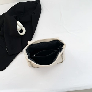 Vue intérieure montrant le compartiment zippé et la chaîne du sac en cuir PU beige
