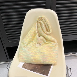 Detail of colorful striped knit tote bag showing soft mohair texture and brand label