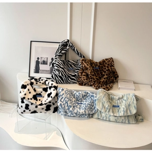 Detailed view of plush animal print shoulder bags in zebra, leopard and cow patterns