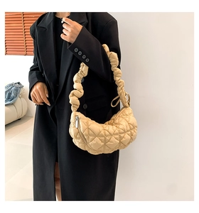 Detailed view of quilted cloud bag with scrunchie strap on black coat