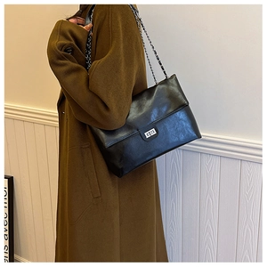 Classic black PU leather chain bag worn by model with silver rectangle turn-lock