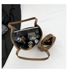 Flat lay of brown PU tote bag with inner pouch showing large storage capacity
