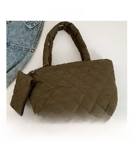 Detail view of dark brown quilted cotton handbag with matching mini coin purse attachment