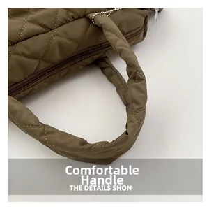 Close-up of quilted nylon handbag detail showing soft handle and metal zipper teeth