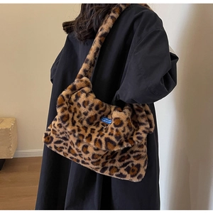 Detail view of leopard print plush tote bag with a soft texture and blue accent label
