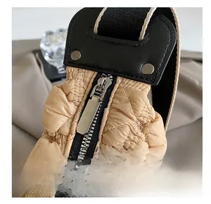 Dettaglio della cerniera argentata e del tessuto in nylon trapuntato della borsa a spalla