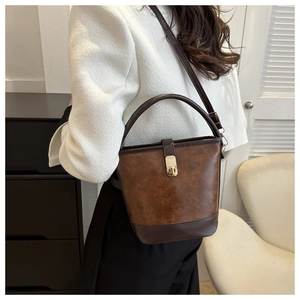 Detail einer Vintage-Beuteltasche aus braunem PU-Leder mit goldenem Drehverschluss