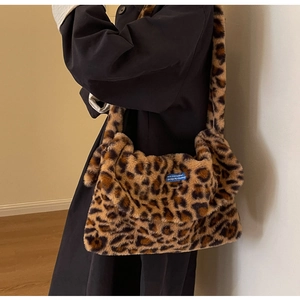 Detail shot of plush leopard print shoulder bag with a blue vintage woven label