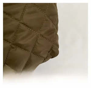 Detail view of the quilted diamond pattern and high-quality brown nylon fabric on a handbag