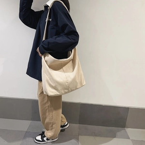 Dettaglio della borsa tote in velluto a coste bianco crema con trama e tracolla larga