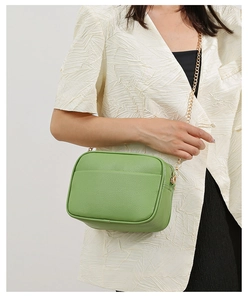 Detail shot of green camera bag with lychee grain texture and gold chain strap