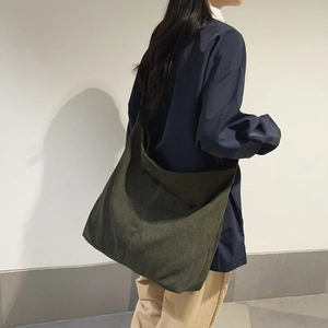 Dettaglio di una grande borsa tote in velluto a coste verde scuro e la sua trama a coste