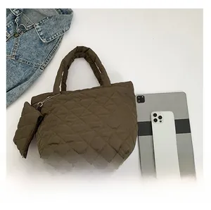 Macro view of brown quilted nylon handbag set with matching mini pouch and accessories