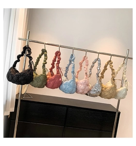 Quilted cloud tote bags in multiple colors with stylish scrunchie handles on metal rack