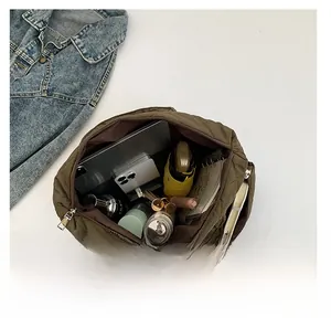 Olive green quilted handbag interior showing large capacity with phone and umbrella