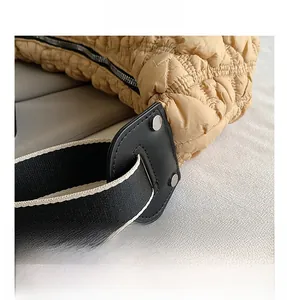 Dettaglio della borsa tote in nylon trapuntato kaki con inserti in pelle e tracolla a righe