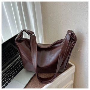 Detail of a vintage coffee brown hobo bag with glossy finish and silver buckle