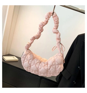 Close-up of pink quilted bubble bag with puffy textures and decorative bow details