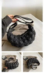 Dettaglio della borsa a mezzaluna in nylon trapuntato nero con tracolla in tessuto regolabile