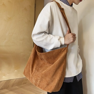 Borsa a tracolla in velluto a coste marrone su un modello, design tote retrò e casual